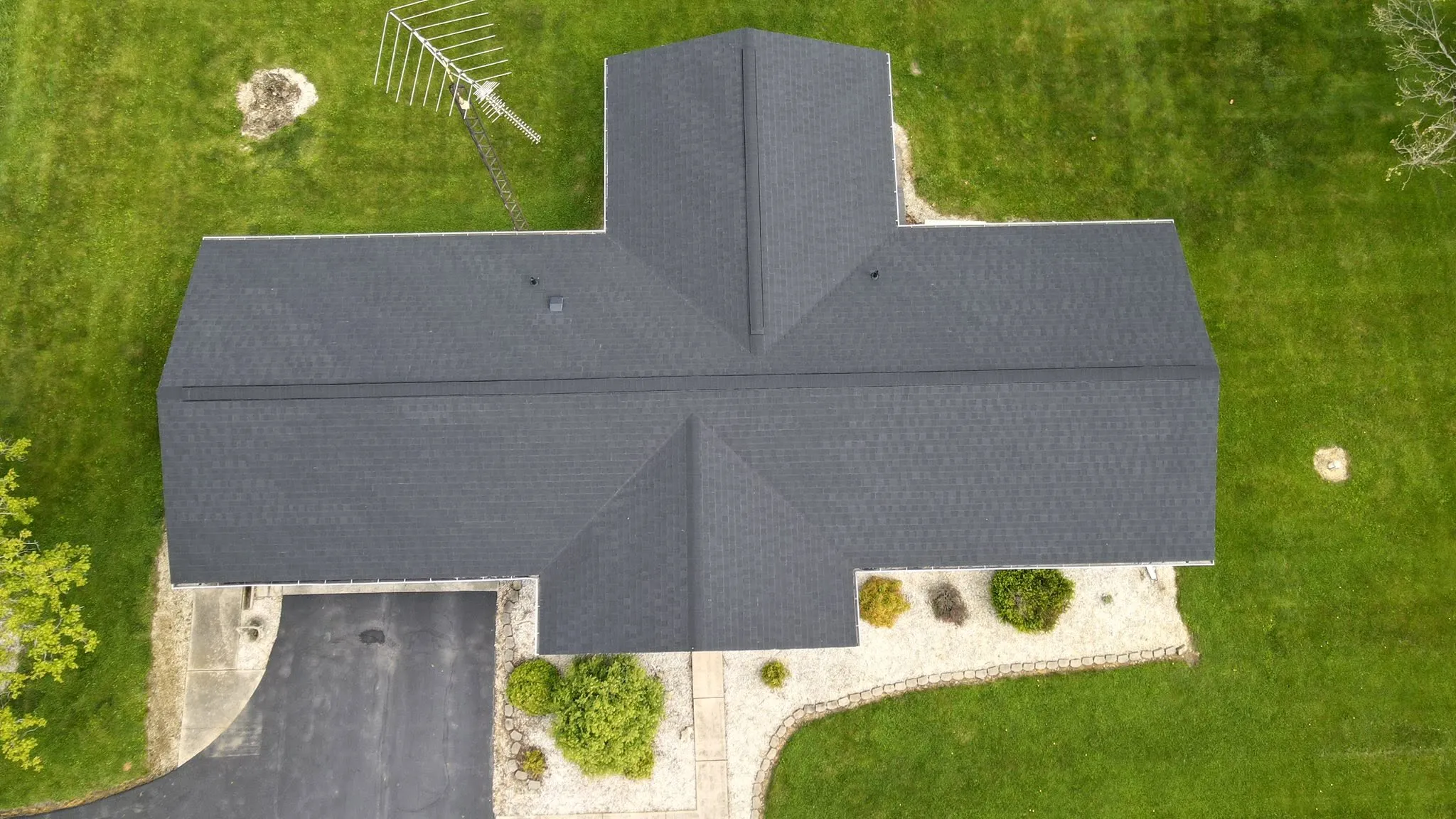 Drone view of a new black architectural shingle roof on a cross-gable home in Logan County, Ohio